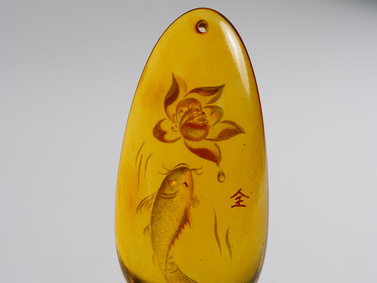 Yihen Natural Amber master carving 'Fish and Lotus'. 47 x 20mm. 28.25 cts.