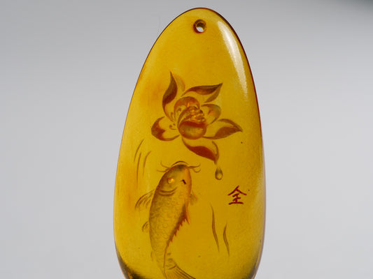 Yihen Natural Amber master carving 'Fish and Lotus'. 47 x 20mm. 28.25 cts.